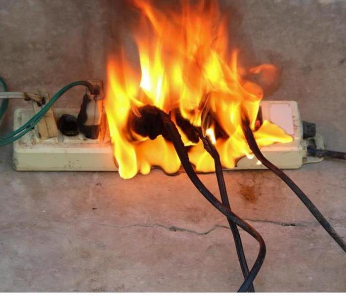 A closeup of a surge protector on fire